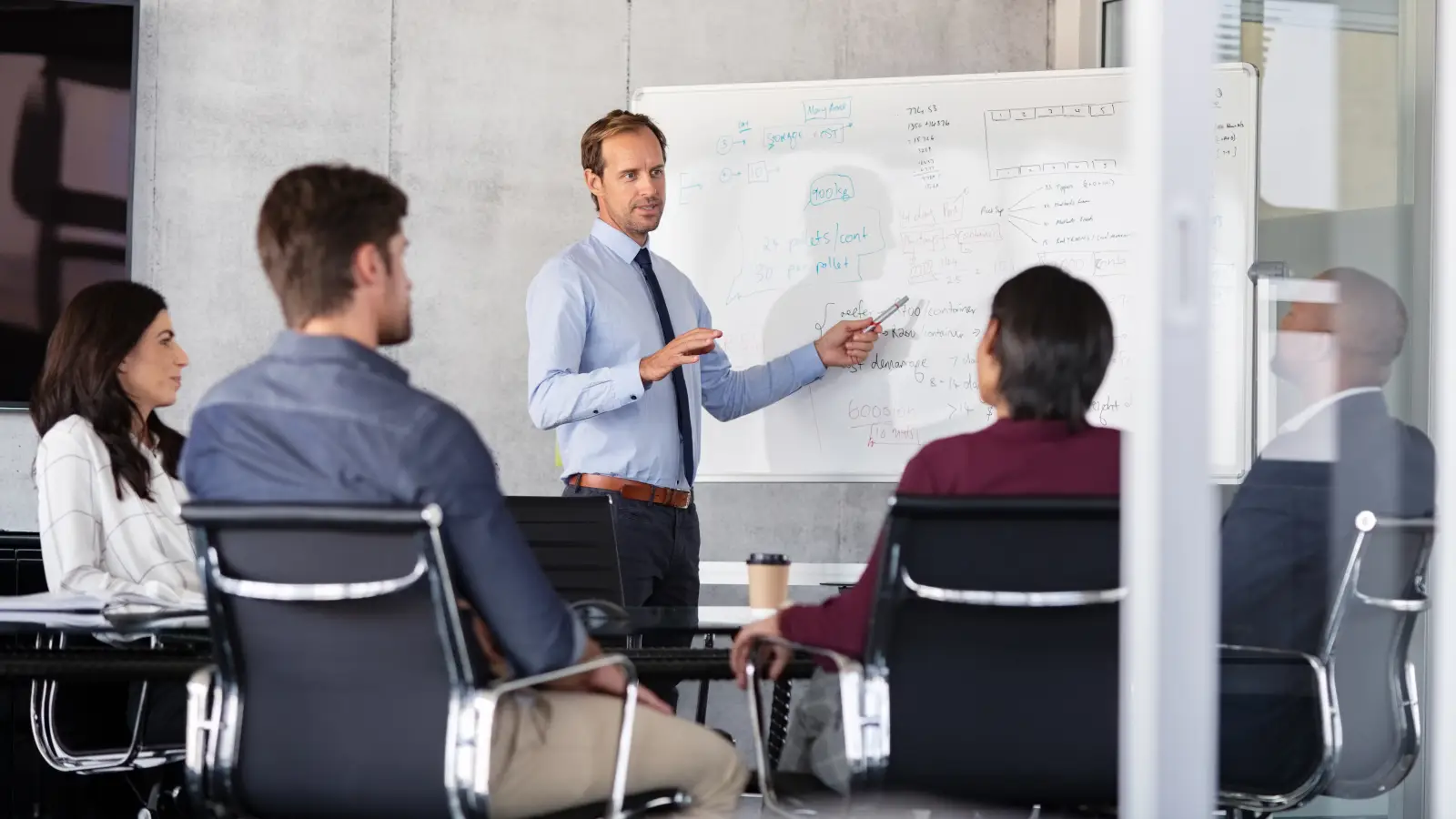 Mature,Businessman,Giving,Presentation,To,His,Colleagues,In,Modern,Office.